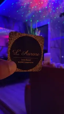 a persons hand holding a sign in front of a table at L'Aurore Love Room de prestige jacuzzi sauna piscine chauffée cuisine in Carpentras