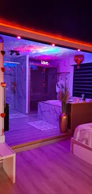 a living room with purple lighting and a couch at L'Aurore Love Room de prestige jacuzzi sauna piscine chauffée cuisine in Carpentras