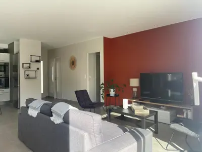 a living room with a couch and a flat screen tv at Magnifique villa avec piscine extérieure in Alleins