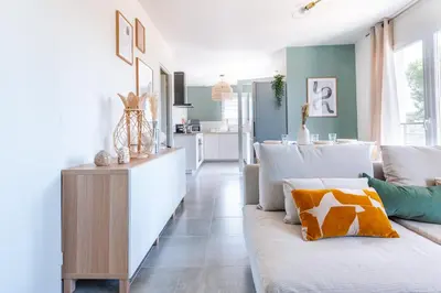 a living room with a white couch and a kitchen at Havre de nature Provence in Morières-lès-Avignon