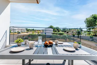 a table with plates of food on a balcony at Havre de nature Provence in Morières-lès-Avignon