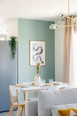 a dining room with a white table and a blue wall at Havre de nature Provence in Morières-lès-Avignon