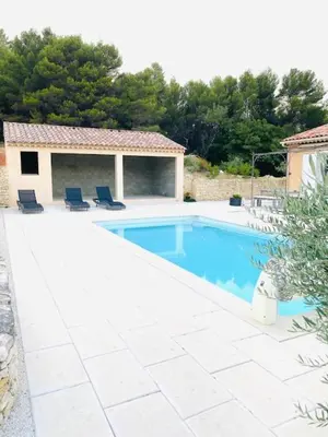 a swimming pool with two chairs and a house at Jolie maison de 110 m 2, pour 6 personnes, au calme, avec piscine in Les Cordiers