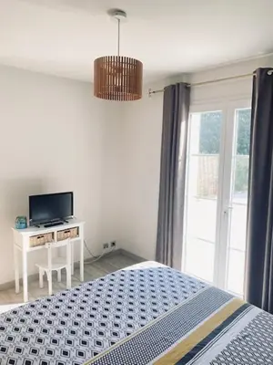 a bedroom with a bed and a tv and a window at Jolie maison de 110 m 2, pour 6 personnes, au calme, avec piscine in Les Cordiers