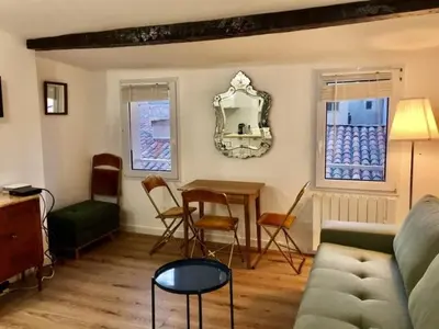 a living room with a couch and a table and chairs at Petit cocoon Aixois in Aix-en-Provence