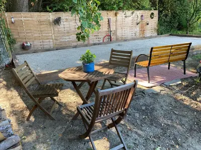 three wooden chairs and a wooden table with a potted plant at Les Hauts d'Eyragues gîte Aigue Marine Meublé classé 4 étoiles in Eyragues