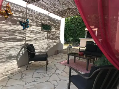 a patio with a butterfly on the wall at Les Hauts d'Eyragues gite Rêverie Meublé classé 4 étoiles in Eyragues