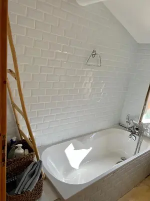 a white bath tub sitting in a bathroom at Charming village house in Goult in Goult