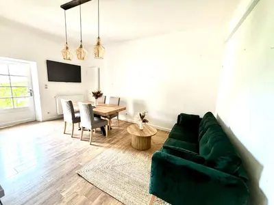 a living room with a green couch and a table at Appartement eygalieres avec petit jardin in Eygalières