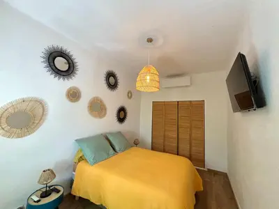 a bedroom with a bed and a tv and mirrors at Appartement eygalieres avec petit jardin in Eygalières