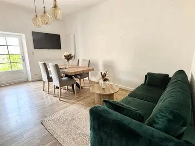 a living room with a green couch and a table at Appartement eygalieres avec petit jardin in Eygalières