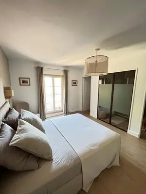 a bedroom with a large white bed and a large window at Le Mas Justin in Gordes