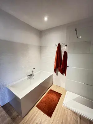 a white bathroom with a tub and a shower at Le Mas Justin in Gordes