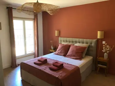 a bedroom with a large bed with red walls at Le Mas Justin in Gordes