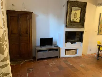 a living room with a television on a table at La Maison Rose in Caromb