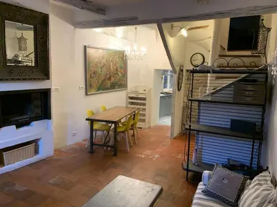 a living room with a table and a dining room at La Maison Rose in Caromb