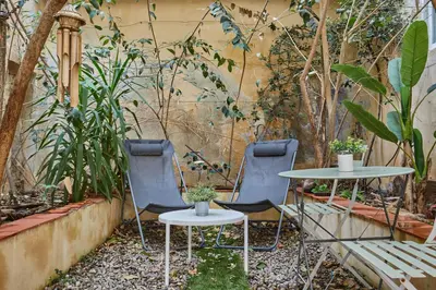 two chairs and a table in a garden at Appart Aix sauna jacuzzi balneo spa privatifs hyper centre historique cour intérieur in Aix-en-Provence