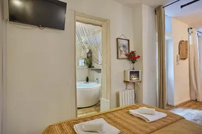 a bathroom with a bed and a bath tub at Appart Aix sauna jacuzzi balneo spa privatifs hyper centre historique cour intérieur in Aix-en-Provence