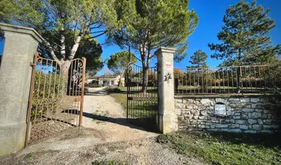 a gate to a house with a stone wall at Villa avec Piscine et Vues Imprenables in Villars