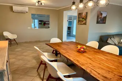 a dining room with a wooden table and white chairs at Villa avec Piscine et Vues Imprenables in Villars
