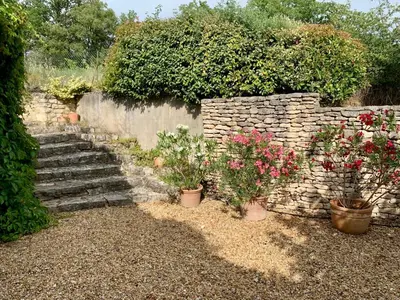 a stone wall with a bunch of plants and flowers at Villa avec Piscine et Vues Imprenables in Villars