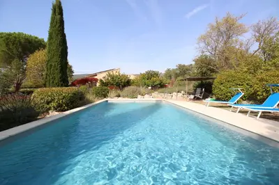 a swimming pool with two blue chairs in a yard at Villa avec Piscine et Vues Imprenables in Villars