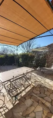 a table and chairs under a large umbrella at Bastidon Plein Sud in Gordes