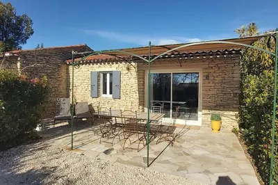a patio with a table and chairs in front of a building at Bastidon Plein Sud in Gordes