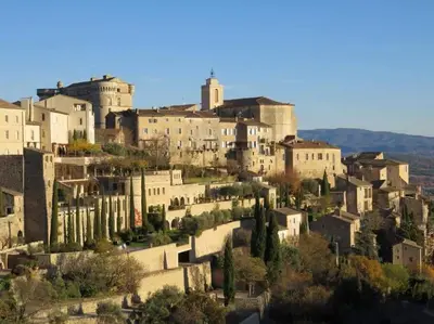 a group of buildings on a hill with trees at Bastidon Plein Sud in Gordes