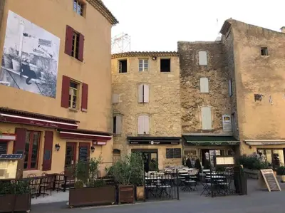a building with tables and chairs in a courtyard at Bastidon Plein Sud in Gordes
