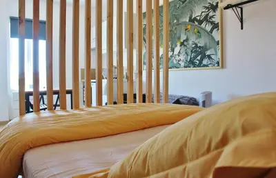 a bed with a yellow blanket on top of it at Joli studio au calme, centre historique de Pertuis in Pertuis