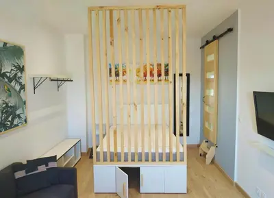 a crib in the middle of a living room at Joli studio au calme, centre historique de Pertuis in Pertuis