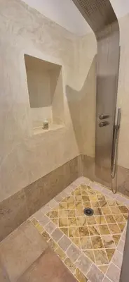 a bathroom with a shower with a tile floor at Cocon du Papillon à Lourmarin in Lourmarin