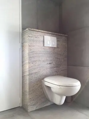 a bathroom with a white toilet and a brick wall at La maison de Marie Hélène 2 piscine partagée in Aix-en-Provence