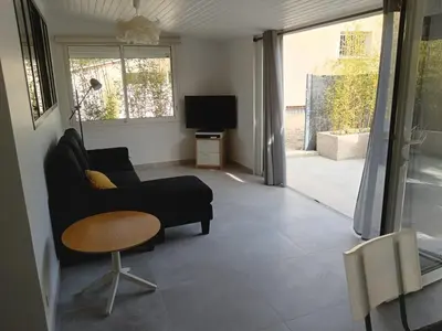 a living room with a couch and a table and a tv at La maison de Marie Hélène 2 piscine partagée in Aix-en-Provence