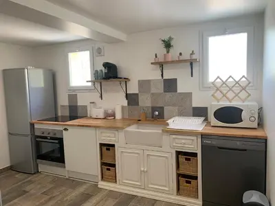a kitchen with a refrigerator and a microwave at Ravissant logement avec jacuzzi in Lançon-Provence