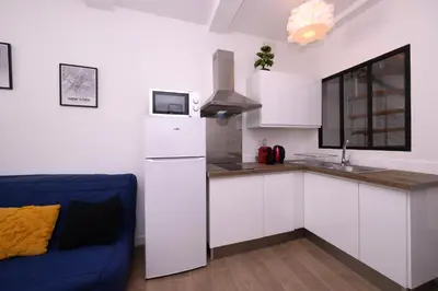 a kitchen with a white refrigerator and a blue couch at Le Nostradamus - Magnifique appartement cours principal plein centre avec parking in Salon-de-Provence
