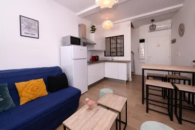 a living room with a blue couch and a kitchen at Le Nostradamus - Magnifique appartement cours principal plein centre avec parking in Salon-de-Provence