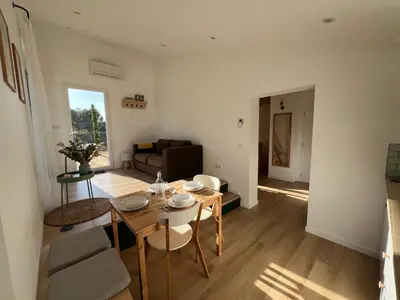 a living room with a table and a couch at Paisible gîte moderne avec vue sur le Luberon in La Motte-dʼAigues