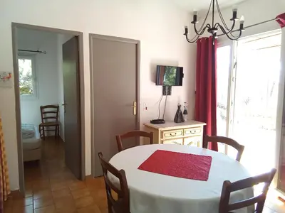 a dining room with a white table with a red rug at Mes deux Gîtes de l'Ocre in Villars