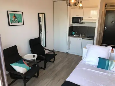 a room with two chairs and a bed and a kitchen at Ma place au sud terrasse à 2 pas d’Aix in Éguilles