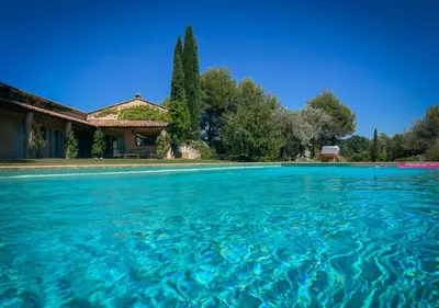 a swimming pool in front of a house at La Villa La Source à Aix en Provence in Aix-en-Provence