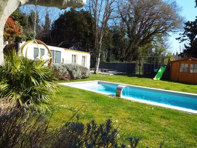 a swimming pool in a yard with a playground at Gîte de Fanny du Moulin de Tartay en Avignon in Avignon