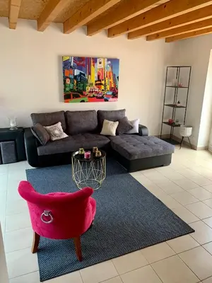 a living room with a couch and a table at Au cœur de l’Isle sur sorgue in LʼIsle-sur-la-Sorgue