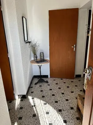 a hallway with a table next to a door at Gîte de la bastide in Monteux
