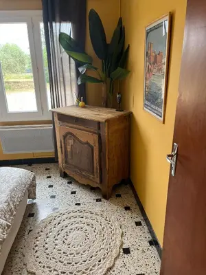 a bedroom with a wooden cabinet and a window at Gîte de la bastide in Monteux