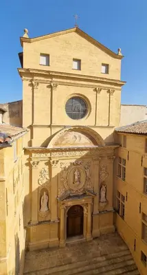 a large building with a tower with two statues on it at Les toits de Mignet in Aix-en-Provence