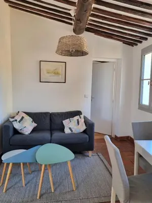 a living room with a blue couch and a table at Les toits de Mignet in Aix-en-Provence