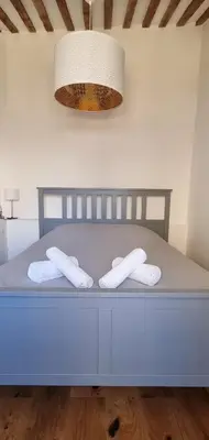 a blue bed with two white pillows and a light at Les toits de Mignet in Aix-en-Provence