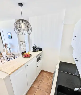 a living room with a table and a kitchen at ALLURA GOLF APPARTEMENT in Saumane-de-Vaucluse